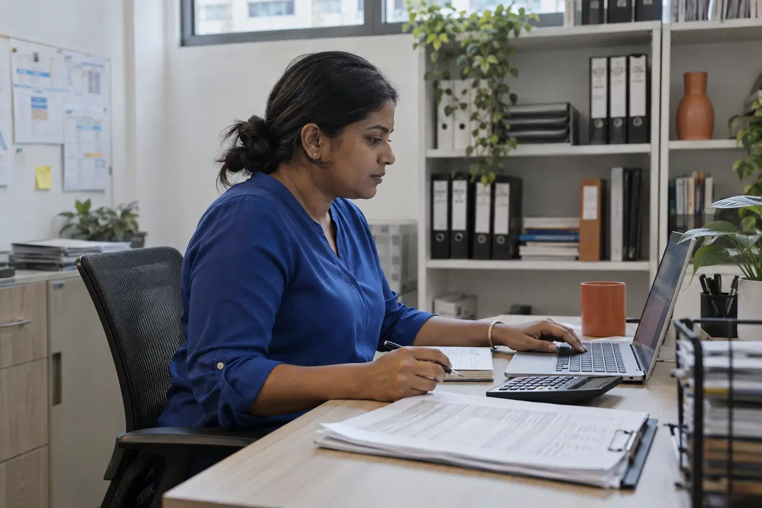 Finance lead reviewing attendance reports at a back-office workstation